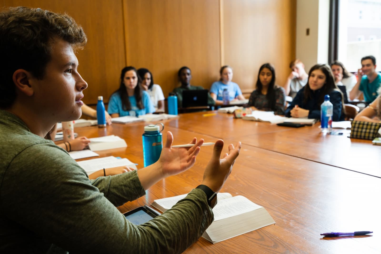 students at a classroom table having a discussion
