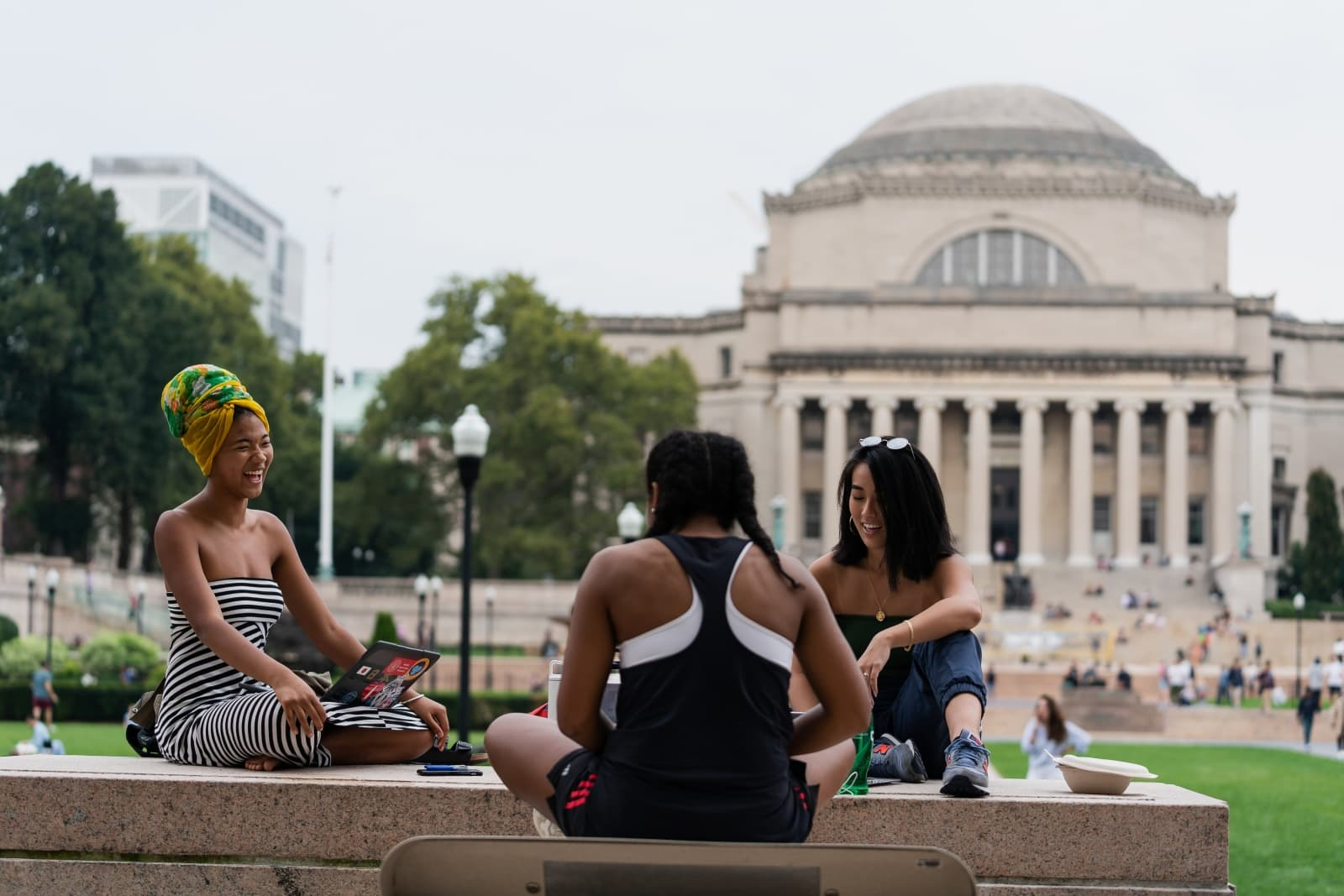 students sitting on campus with Low library in background