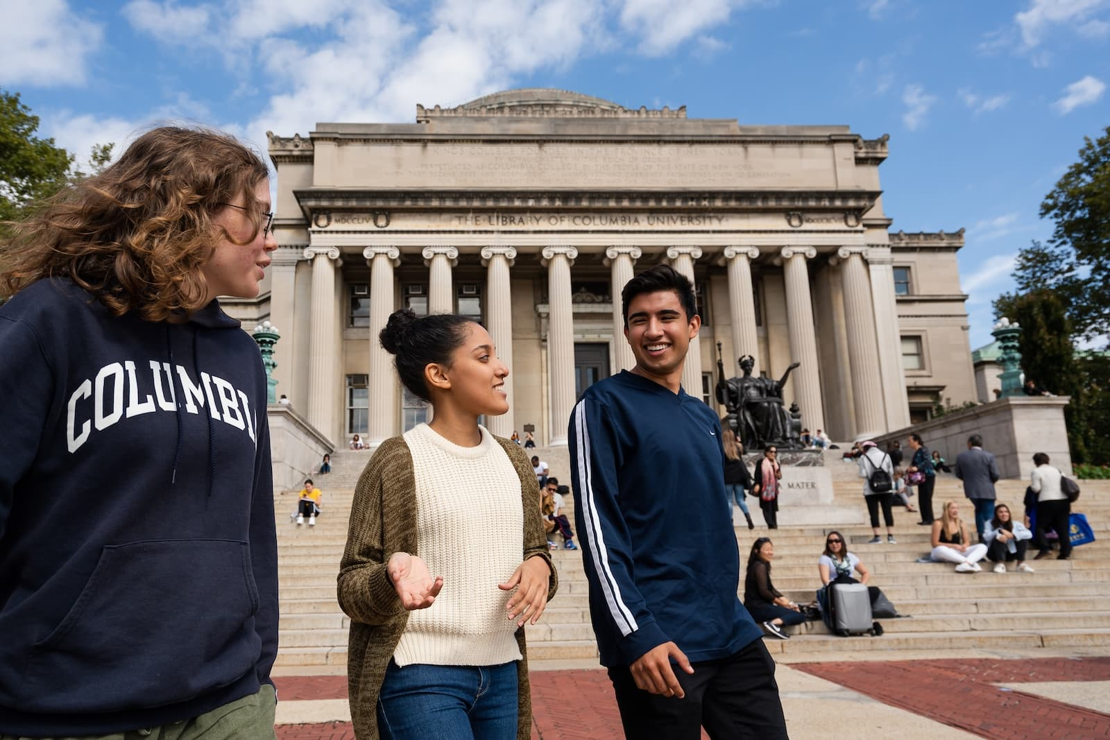 Three students walking across Low Plaza