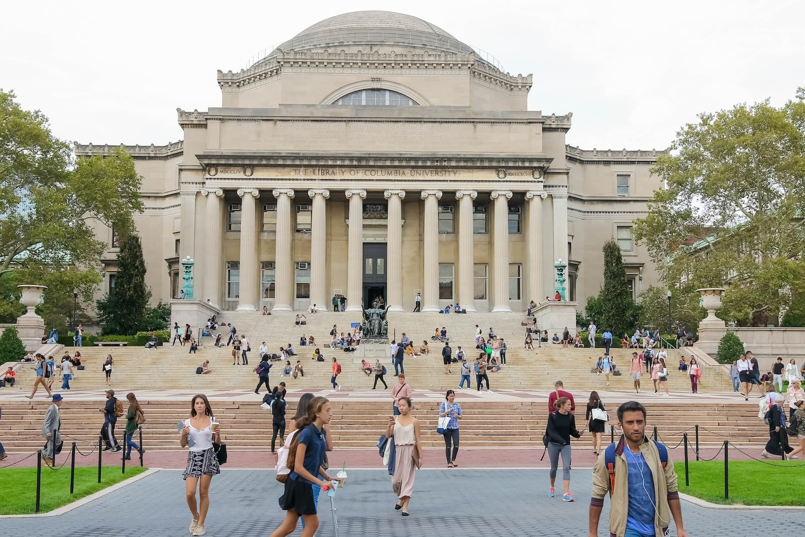 Students walk across College Walk in front of Low Library