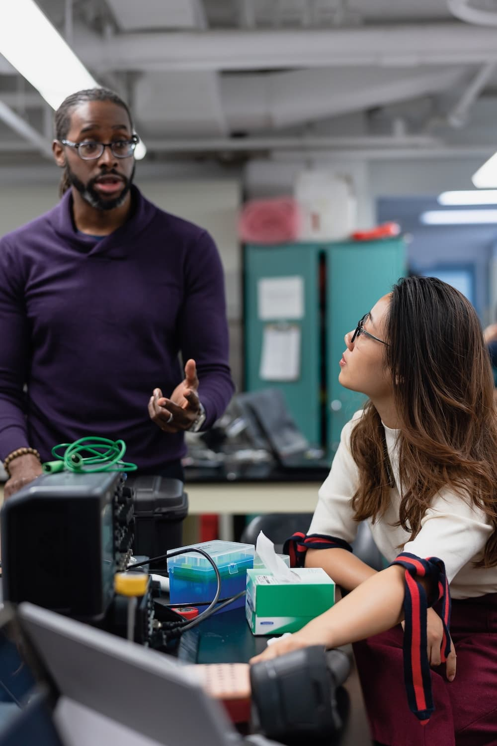 A professor works with a student in an engineering lab