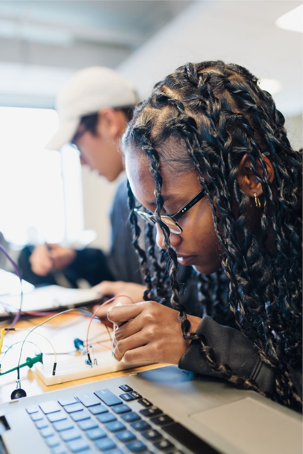 A student works on an electric circuit with a laptop
