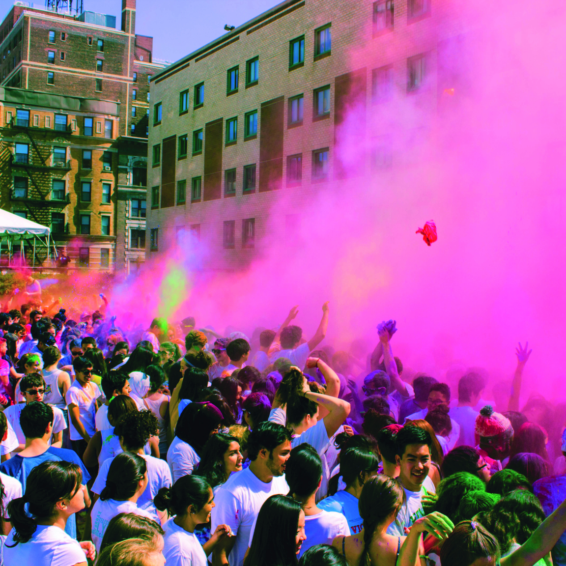 Students celebrating throwing colored powder on campus