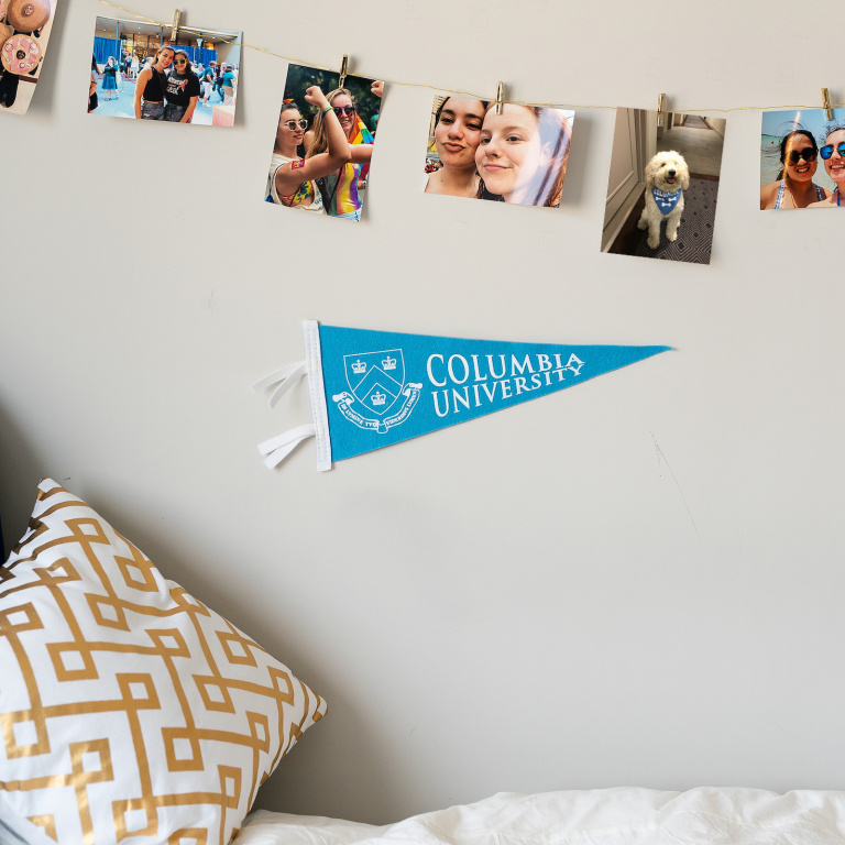 Student dorm room bed with photos on the wall
