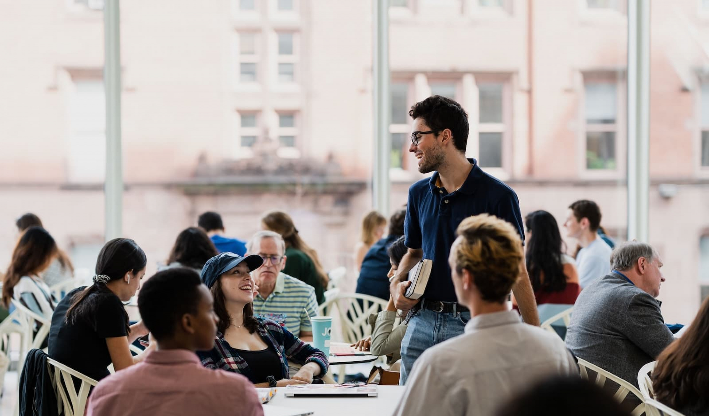Student standing next to table of friends in dining hall