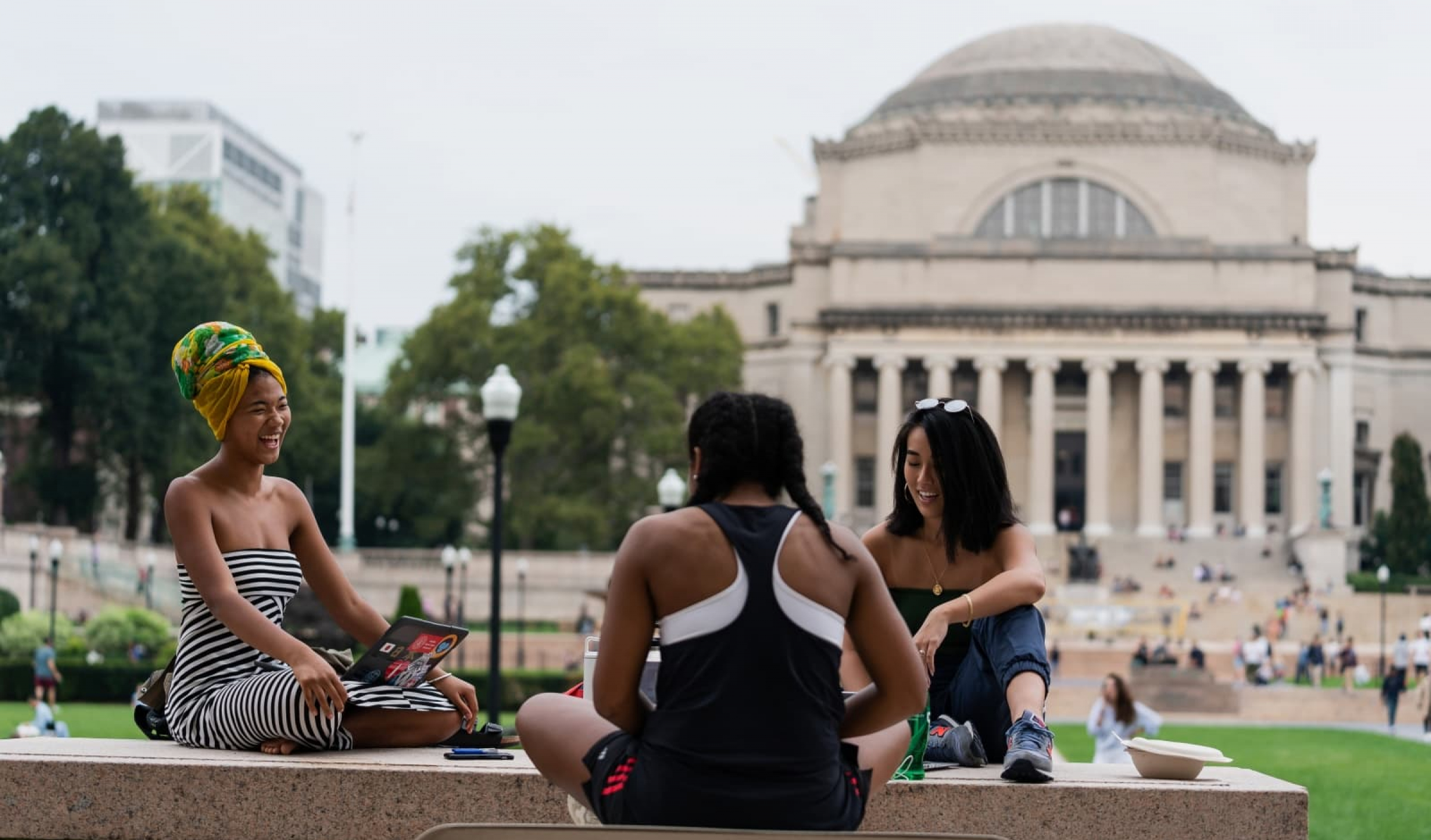 students sitting on campus with Low library in background