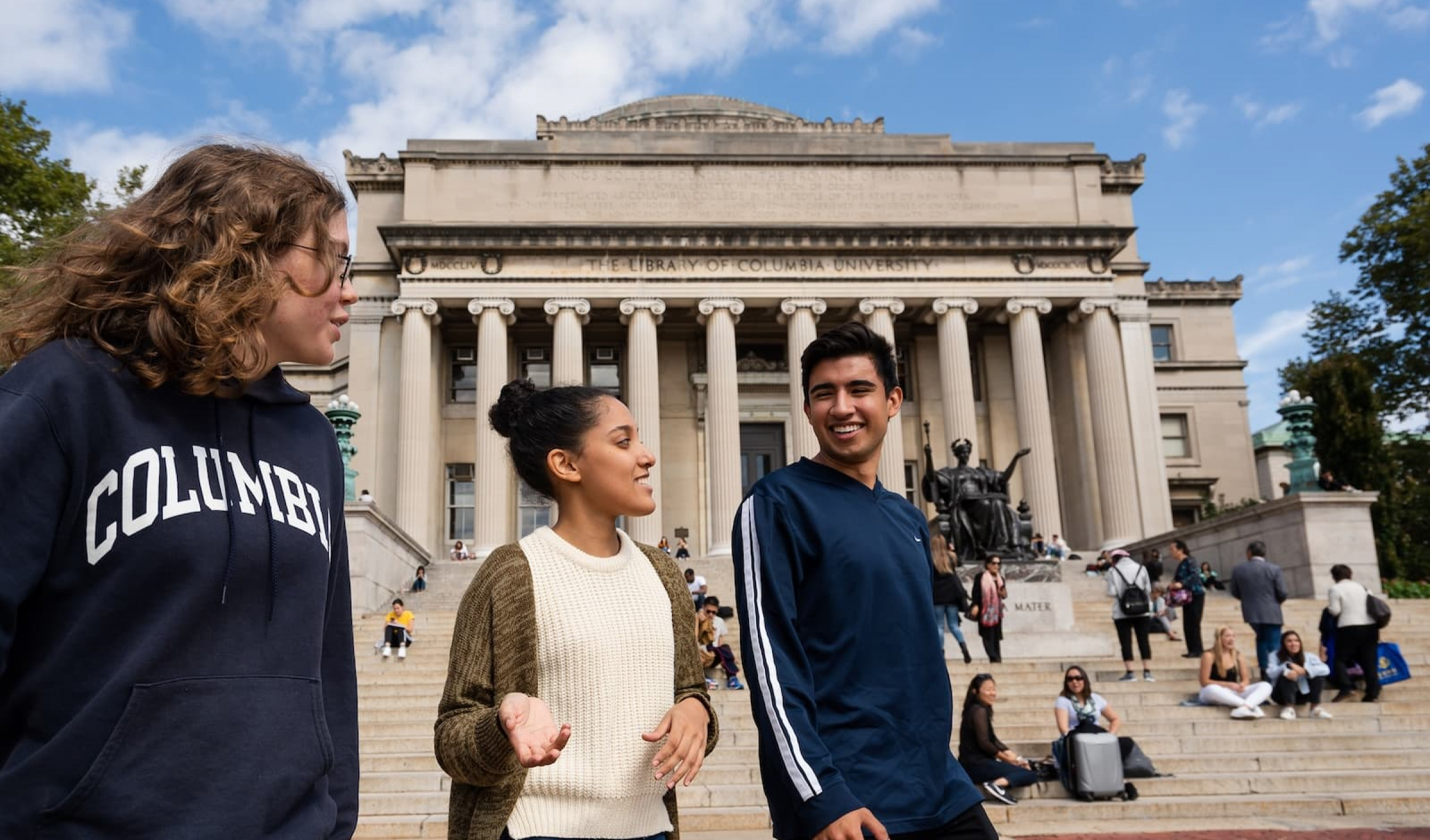 Three students walking across Low Plaza