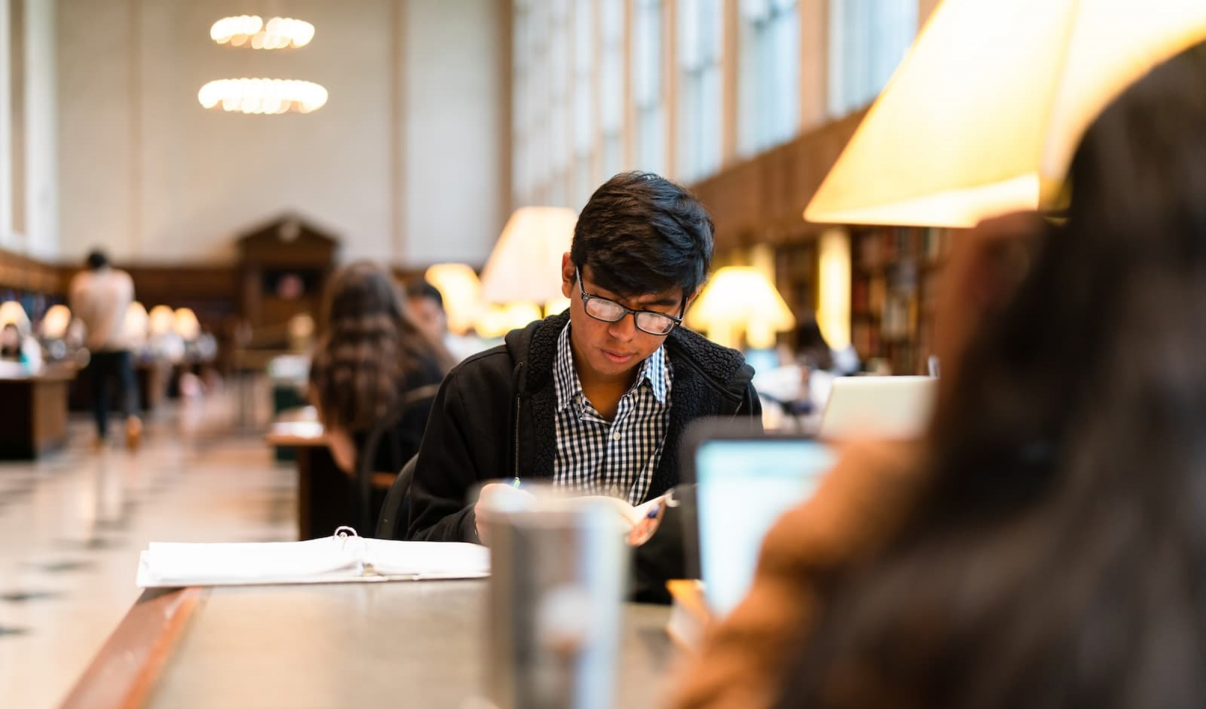 A student reads at a table at Butler Library