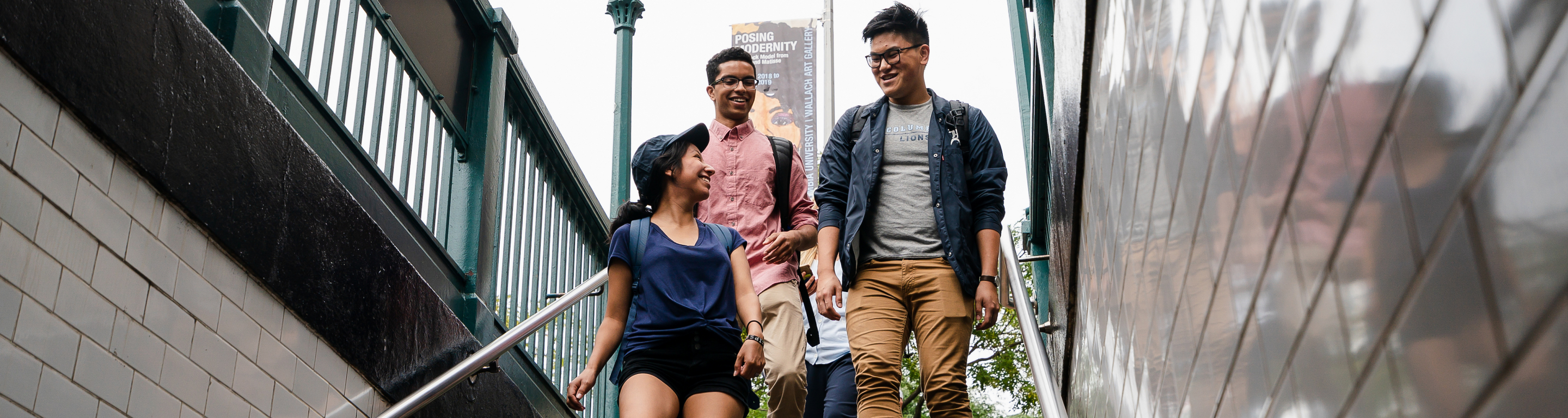 Three students walk down into the NYC suwbay