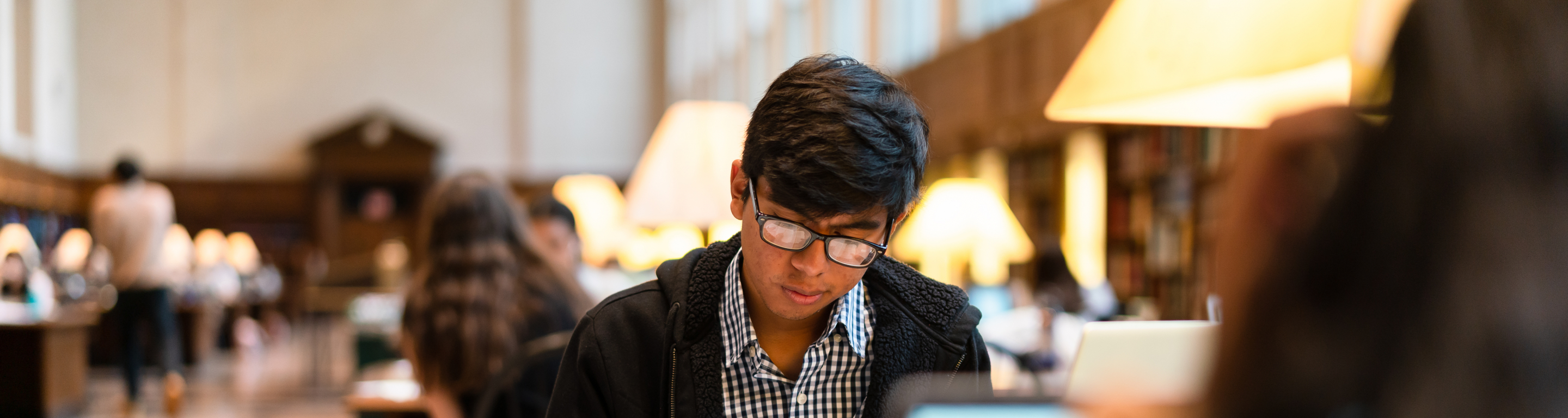 A student reads at a table at Butler Library