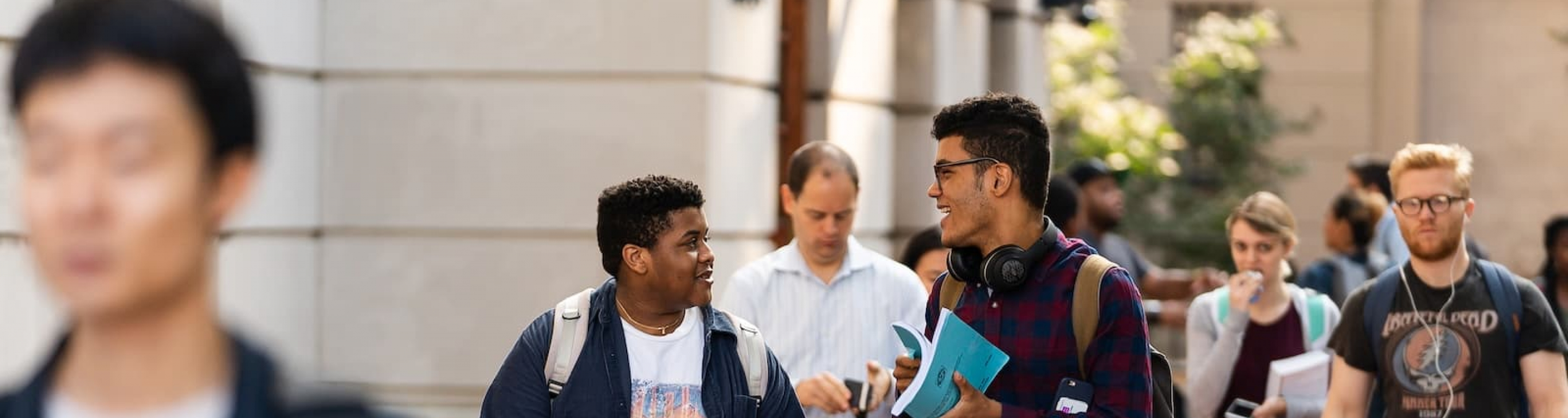 Two students walking behind Hamilton Hall