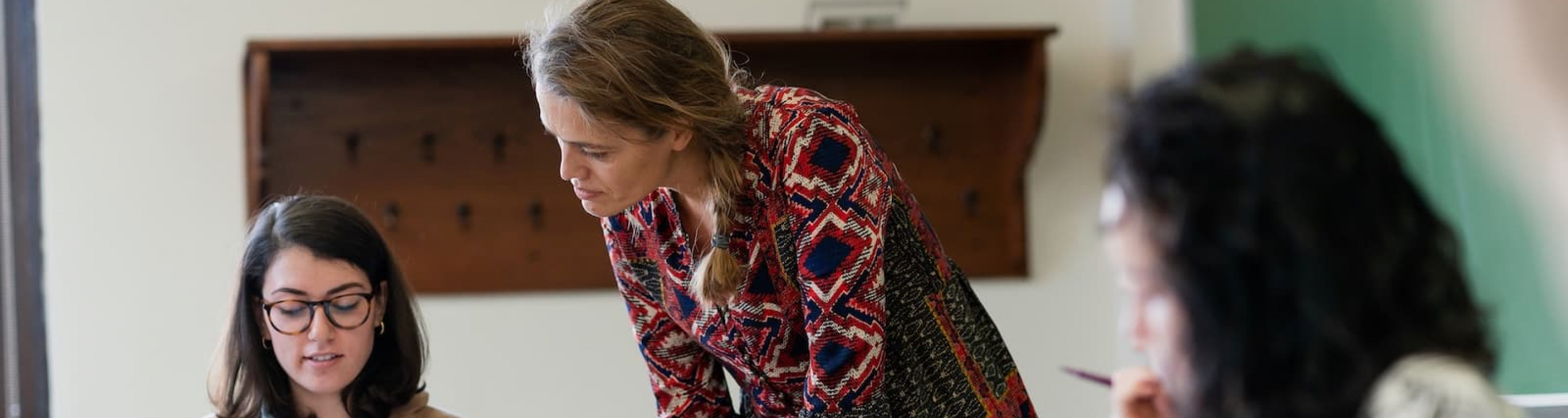 A professor works with a student in the classroom
