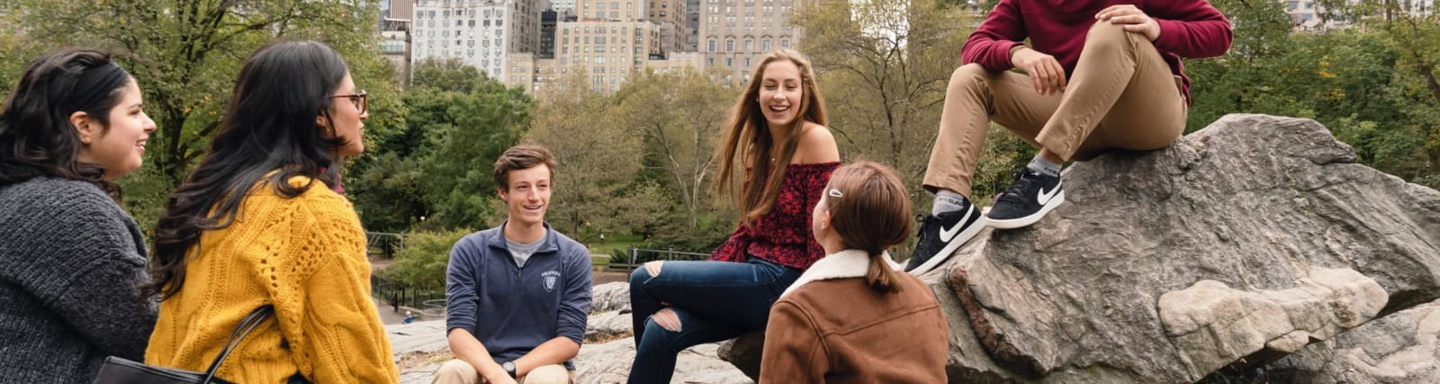 students sitting on a rock in Central Park