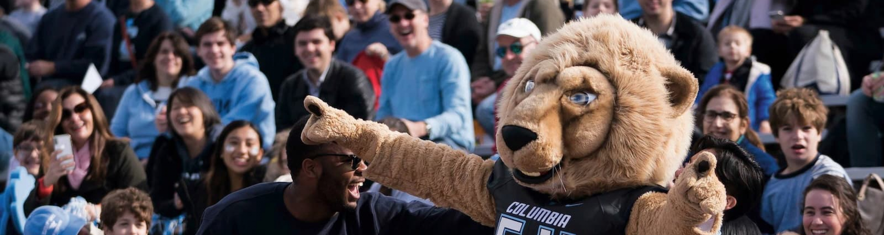 Students carrying Roar-Ee at a football game