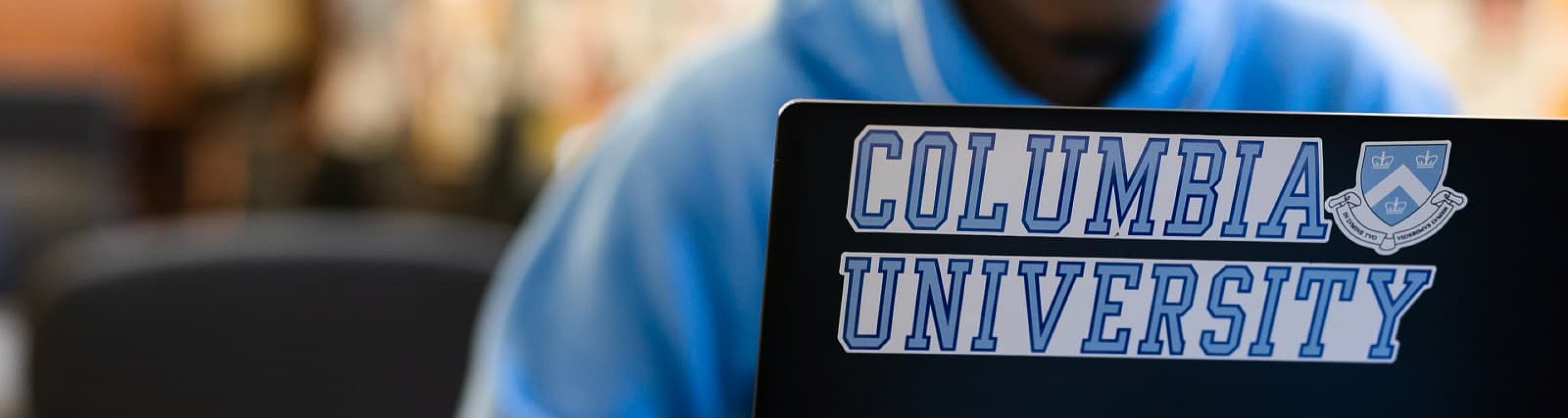Student working at laptop with Columbia sticker