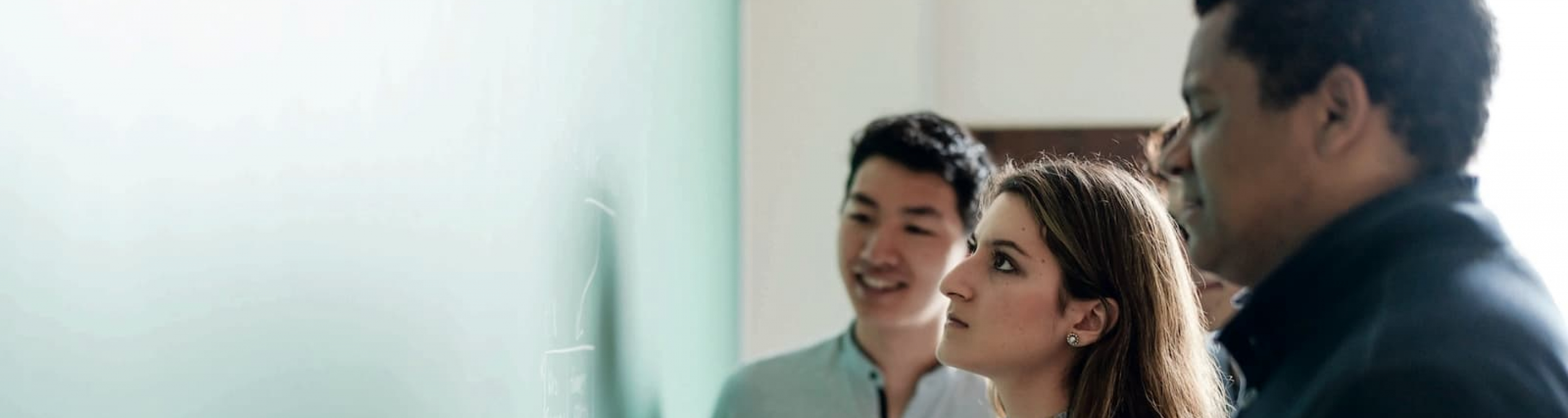 Three students working at a chalkboard
