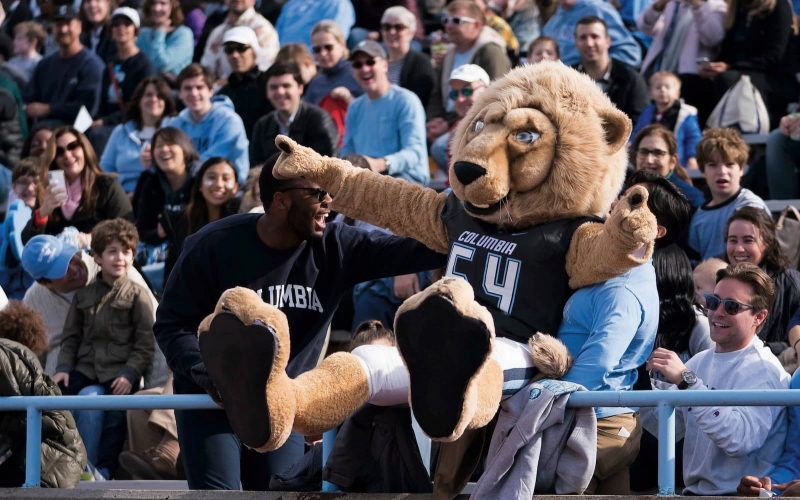 Students carrying Roar-Ee at a football game